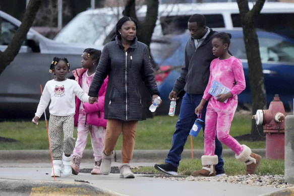 A family leaves from a shelter at the Abundant Life Christian School in Madison, Wisconsin.