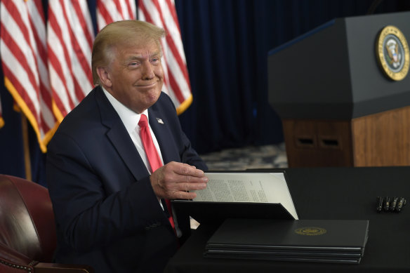 President Donald Trump smiles as he is about to sign four executive orders during a news conference at the Trump National Golf Club in New Jersey on August 8.