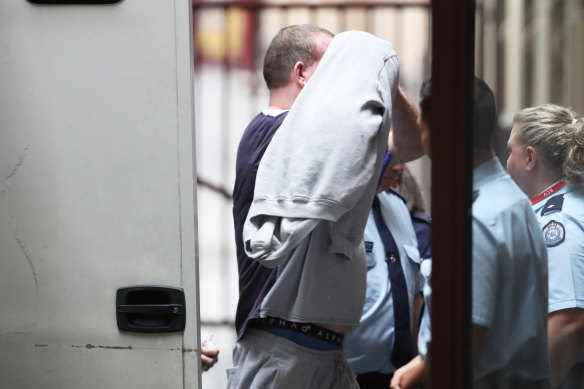 Scott Murdoch covers his face as he arrives at court on Monday.