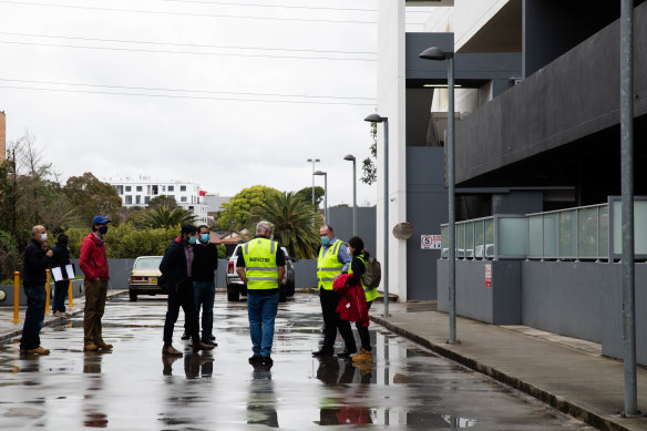 Building inspectors gather outside the Charles Street development on Wednesday afternoon.