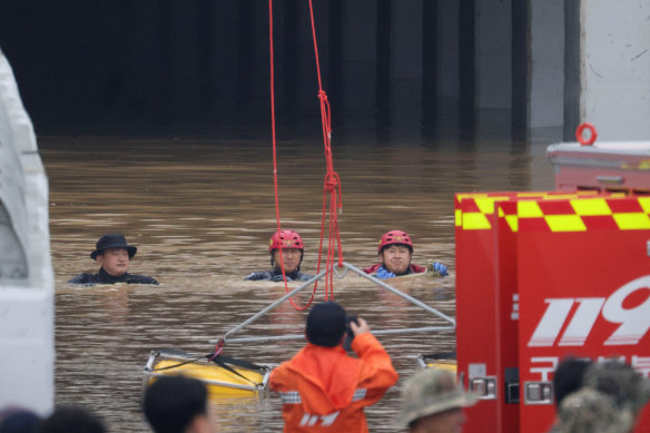 Rescue workers take part in a search and rescue operation near an underpass that has been submerged by a flooded river caused by torrential rain in Cheongju, South Korea on Sunday, July 16.