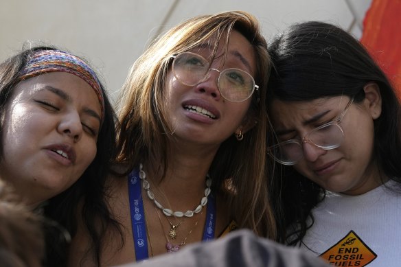 Mitzi Jonelle Tan, of the Philippines, embraces Adriana Calderon Hernandez (right) and other activists at a protest against fossil fuels during the COP28 conference in Dubai.