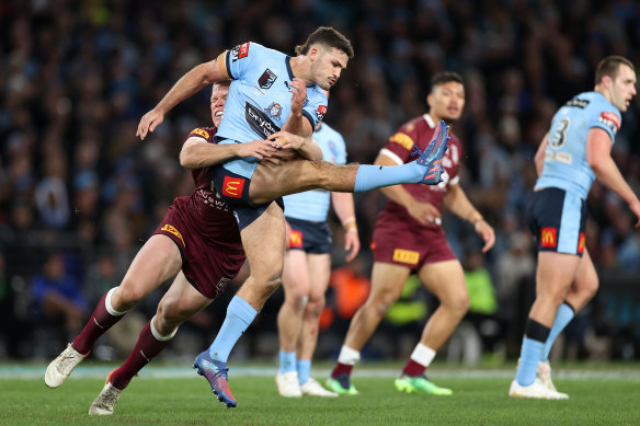 Nathan Cleary is wrapped up by Lindsay Collins after getting a kick away.