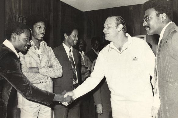 Kerry Packer meets the West Indies cricket team, among them Clive Lloyd to his left and opposite him with his arms folded, Michael Holding, as World Series Cricket gets going in 1977.