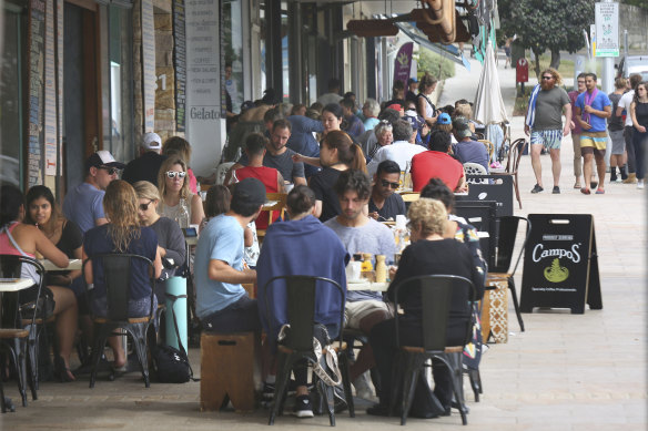 Customers enjoy the cafes on Bronte Beach on a busy Sunday.  The buzz is still missing in Melbourne.