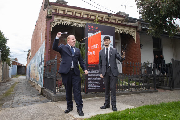 Auctioneer Jonathan West (left) outside 24 Munro Street, Brunswick on Saturday.