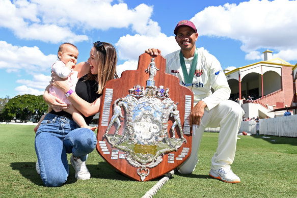 Queensland captain Usman Khawaja celebrates winning the 2021 Sheffield Shield with his wife Rachel and daughter Aisha.