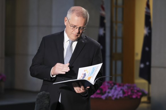 Prime Minister Scott Morrison reading the budget papers in between TV interviews earlier today. 