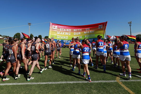 Bulldogs and Giants players run through a joint banner at Henson Park.