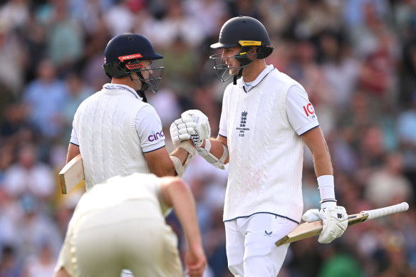 Stuart Broad (right) punches gloves with fellow England batsman James Anderson after play wrapped up on day three.