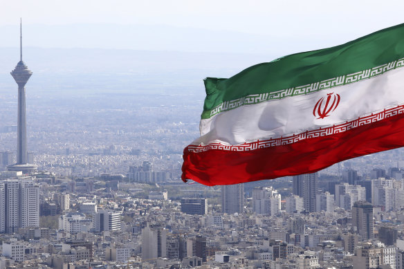 Iran's national flag waves as Milad telecommunications tower and buildings are seen in Tehran, Iran.