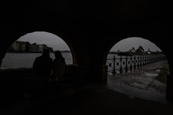 People hide from the rain at Milsons Point on Saturday evening. 