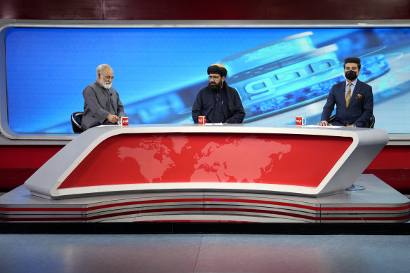 TV anchor Nesar Nabil wears a face mask to protest the Taliban’s new order that female presenters cover their faces, as he reads the news on TOLOnews, in Kabul.