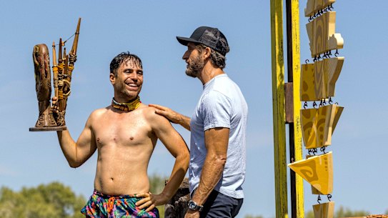 George Mladenov holding his team’s challenge trophy with Australian Survivor host Jonathan LaPaglia.