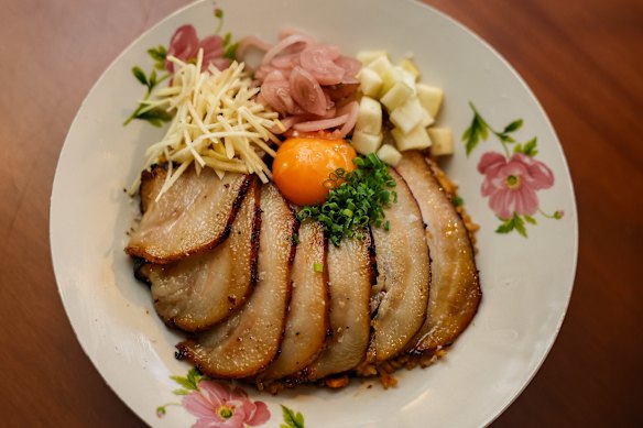 Charred pork jowl rice with tamari egg yolk and fresh condiments to stir through.
