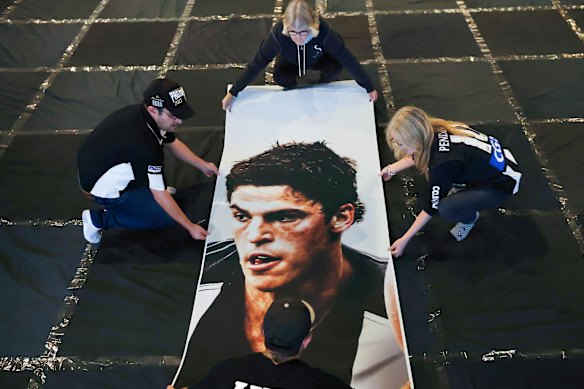 Collingwood's cheer squad working on the team's Scott Pendlebury banner.