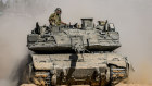 Israeli soldiers drive a tank at a staging ground near the border with the Gaza Strip.