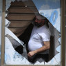 A Lebanese villager looks through a broken window of his house damaged by Israeli shelling in Kfar Kila, a border village with Israel, last week.