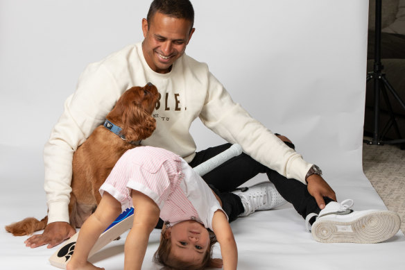 Usman Khawaja, pictured with daughter Aisha and LeBron the dog. To those who suggest he “shuts up and plays cricket”, he says, “At what point do you qualify to have an opinion? … Either we live in this world all together or we don’t.”