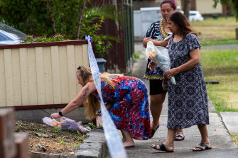 Mourners lay flowers outside the house on Friday.