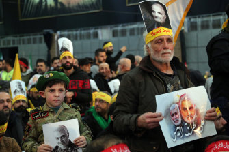 Hezbollah supporters hold pictures of slain Iranian general Qassem Soleimani during a televised speech by Hezbollah's leader Hassan Nasrallah.