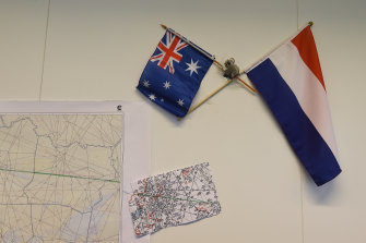 An Australian and Dutch flag hang on the wall next to maps showing the flight path of MH17 in the National Police of the Netherlands criminal investigation building in 2015.  