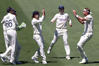 England’s Stuart Broad, right, celebrates with teammates after removing Marcus Harris.