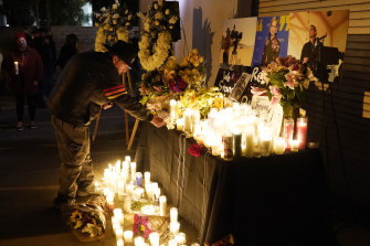 Russ Backers, a stagehand and welder, lays down his union pin for the late cinematographer Halyna Hutchins during a candlelight vigil for her on Sunday (Monday AEDT) in BUrbank, California.