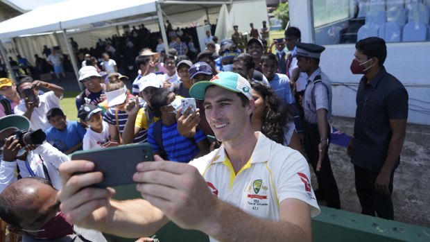 Pat Cummins takes a selfie with fans.