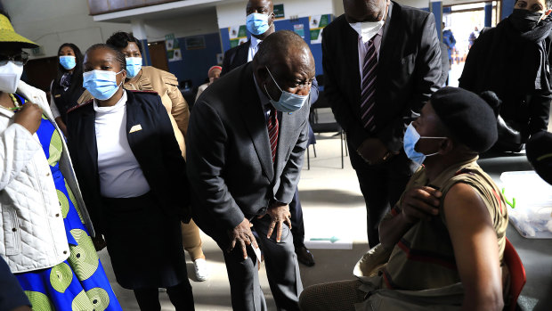 South African President Cyril Ramaphosa greets patients at a vaccination centre in Tembisa. After vaccinating 220,000 people a week in July, South Africa appears on track to inoculate 35 million of its 60 million people by year end.  