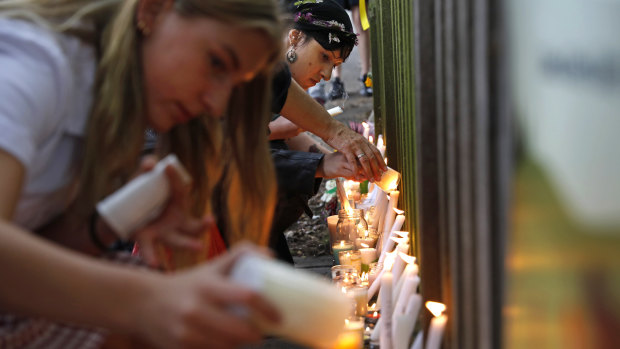 Students light candles as they gather for a vigil to commemorate victims of Friday's shooting.