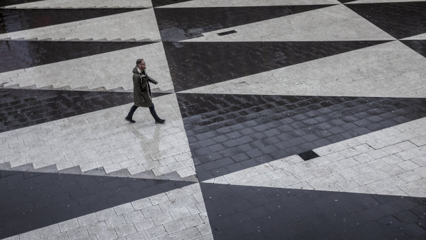 A man crosses an unusually empty square of Sergels Torg in central Stockholm. This time of the year, the square should be full of Christmas stalls and shoppers.