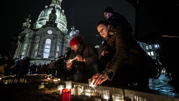 People arrive to light candles next to Frauenkirche cathedral to commemorate the victims of the 1945 Allied firebombing of the city on the 75th anniversary of the bombing in Dresden, Germany. 