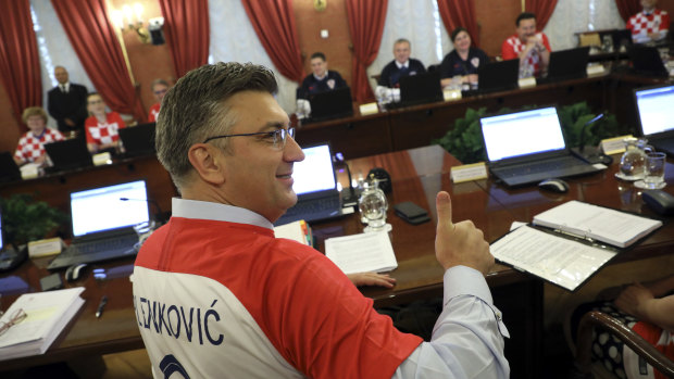 Photo opportunity: Croatia's prime minister Andrej Plenkovic, and cabinet ministers, wear national team jerseys during a government session in Zagreb.