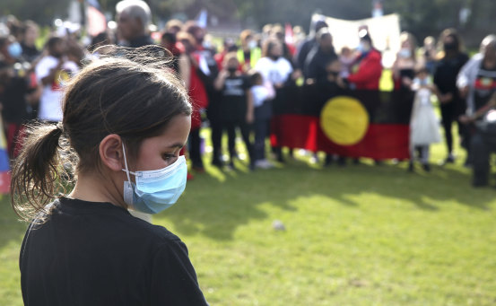 A woman reflects at a Black Lives Matter rally in The Domain on Sunday.