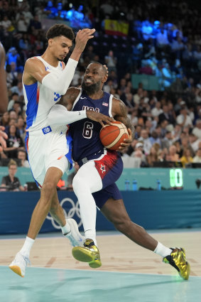 LeBron James drives to the basket against Victor Wembanyama.