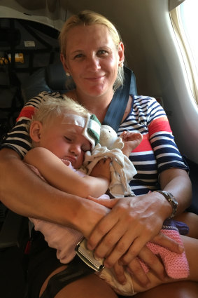 Larissa Petfield cradles her 18-month-old daughter Clare on the Royal Flying Doctor Service flight.