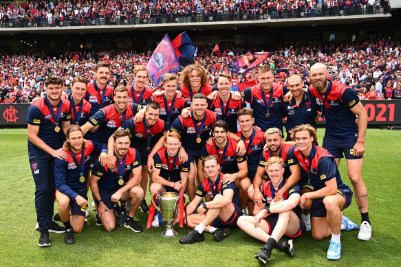 The Demons pose with the trophy in front of their fans.