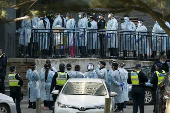 Healthcare workers enter a North Melbourne public housing tower. 