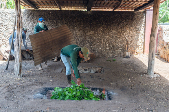 Cooking cochinita pibil (slow-roasted pork) underground at Hacienda Sotuta de Peon.