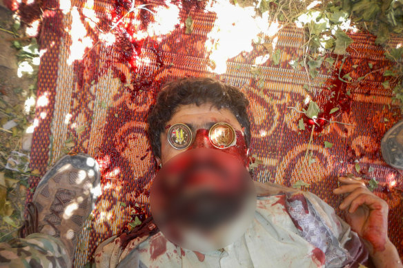A dead suspected Taliban fighter with Australian coins placed on his eyes.