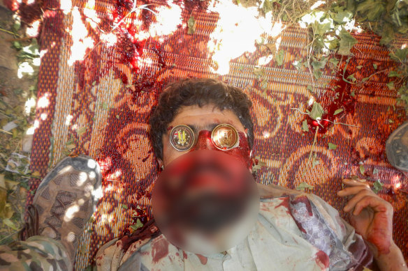 A dead suspected Taliban fighter on whose eyes were placed two souvenir Australian military coins.