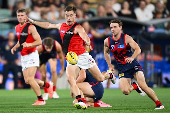 Zach Merrett of the Bombers kicks the ball.