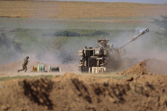An Israeli artillery unit fires toward targets in Gaza Strip from the Israeli border on Saturday.