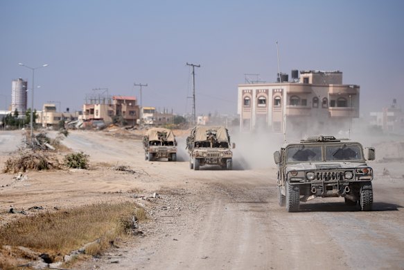 Israeli army vehicles transport a group of soldiers and journalists inside the southern Gaza Strip on Sunday.