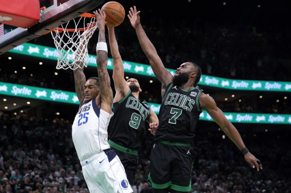 Dallas Mavericks forward P.J. Washington (25) is blocked by Boston Celtics’ Derrick White (9) and Jaylen Brown (7).