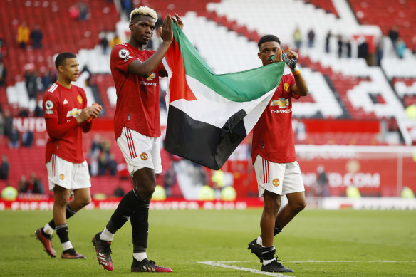 Manchester United duo Paul Pogba and Amad Diallo hold a Palestinian flag after the 1-1 draw with Fulham.