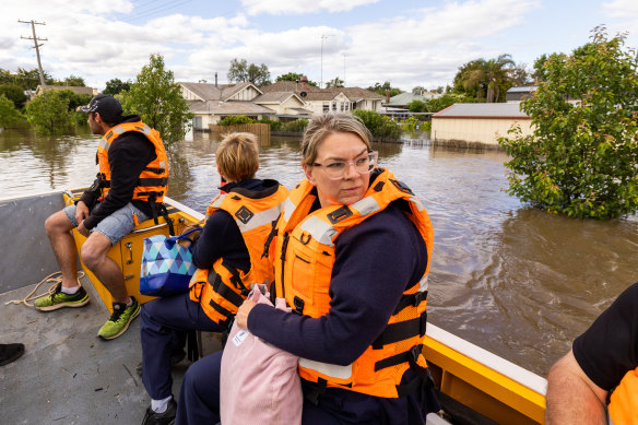 Bailee Harrison, nurse unit manager at Forbes District Hospital, is transported by boat with a crew from Maritime NSW  across flooded streets.