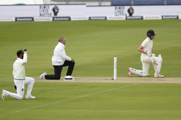 England and West Indian players and the umpires take the knee at the start of the first Test.
