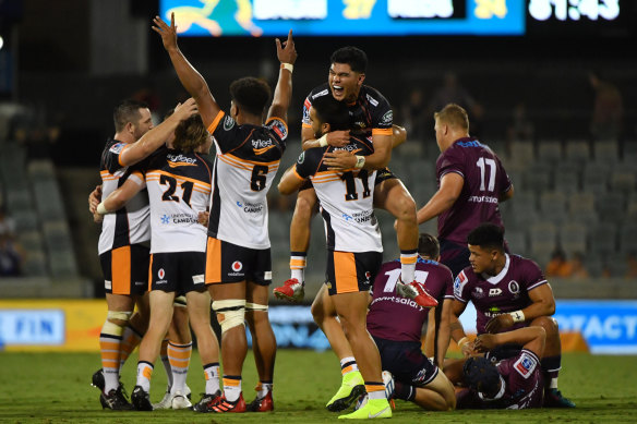 Brumbies players celebrate after their opening-round victory over the Reds in blistering heat in Canberra on Friday.